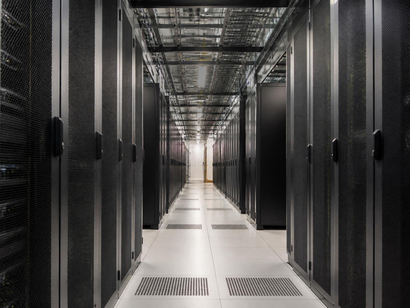 Corridor of server racks inside a contemporary data center.